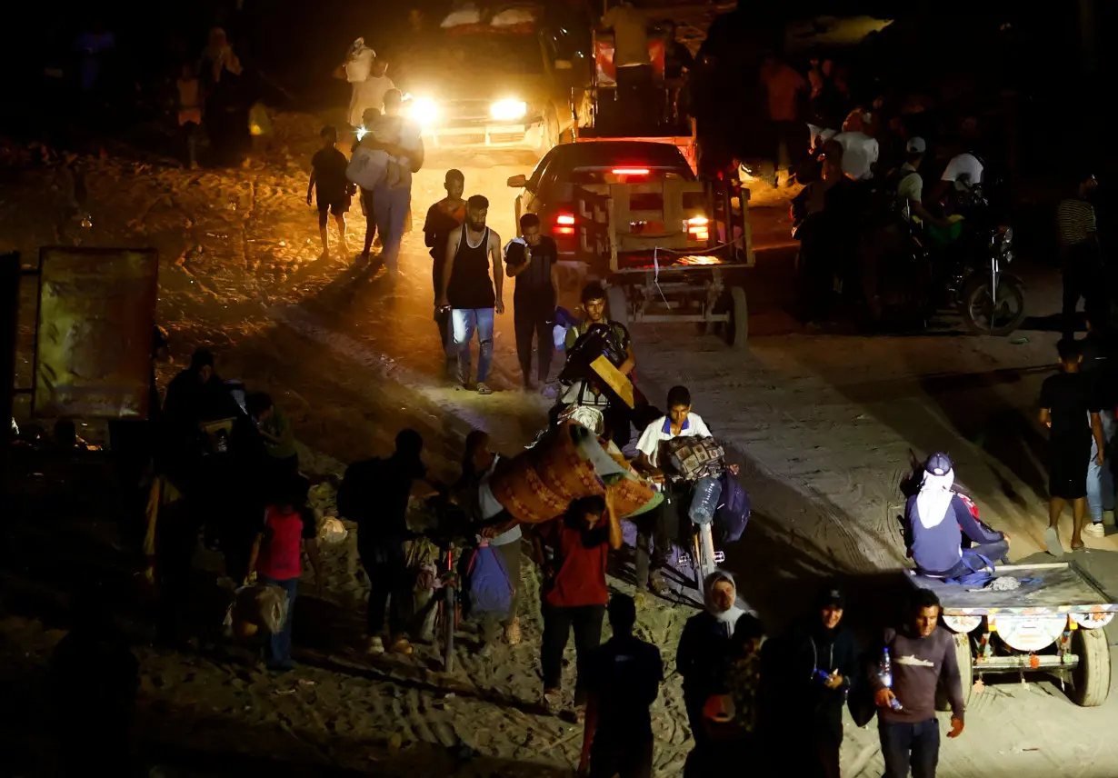 Palestinians, who fled the eastern part of Khan Younis, walk, after they were ordered by Israeli army to evacuate their neighbourhoods, amid Israel-Hamas conflict, in Khan Younis