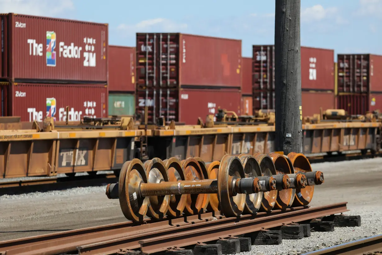 Train wheels are stored next to shipping containers on rail cars at Roberts Bank Superport in Delta