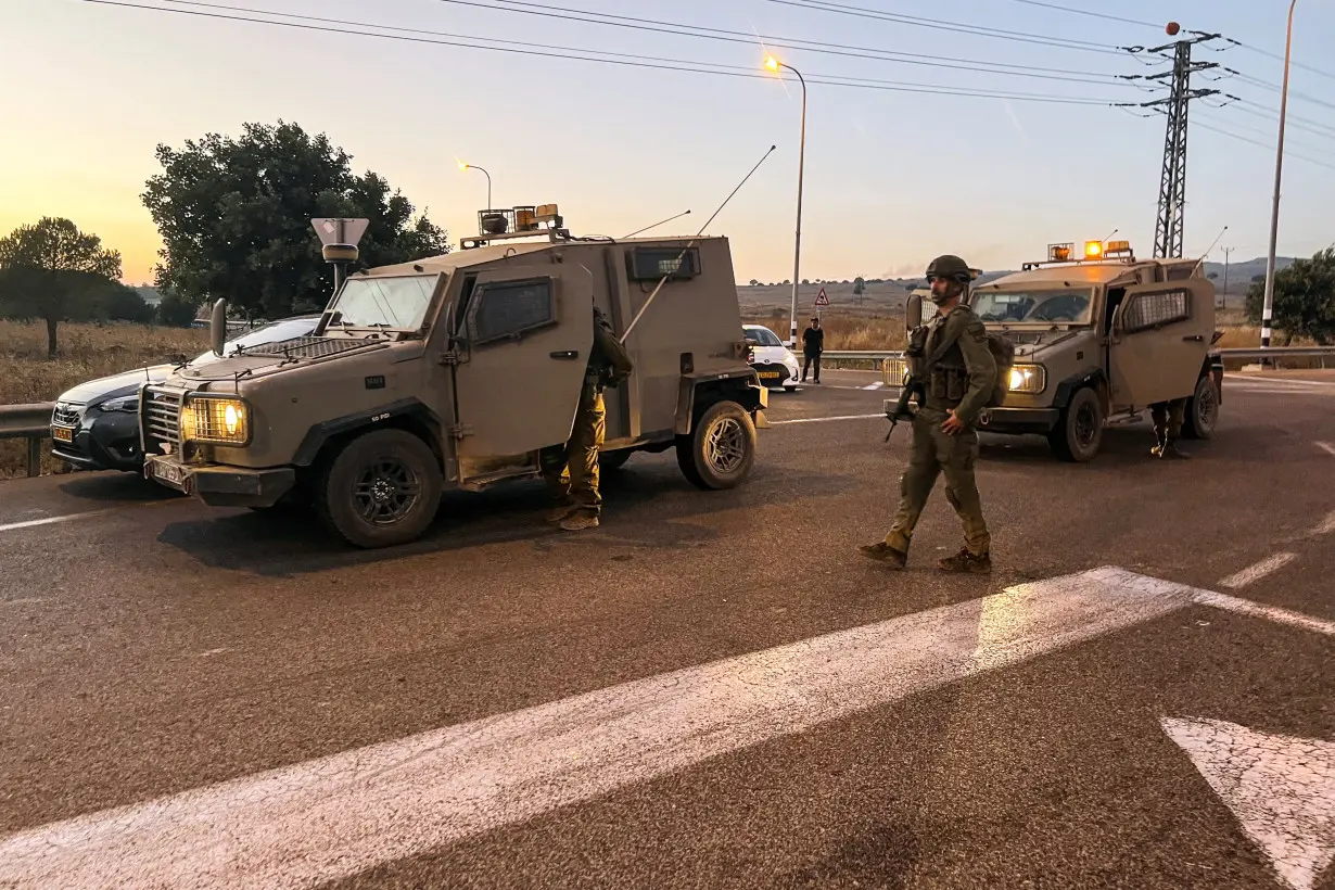 Israeli security block a road after Hezbollah launched projectiles, at the Israeli-occupied Golan Heights