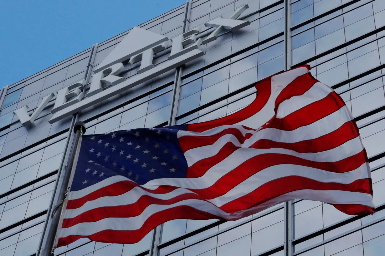 FILE PHOTO: A U.S. flag flies in front of the world headquarters of Vertex Pharmaceuticals in Boston