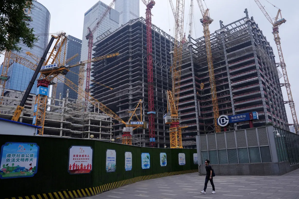 FILE PHOTO: Person walks past a construction site in Beijing's Central Business District (CBD)