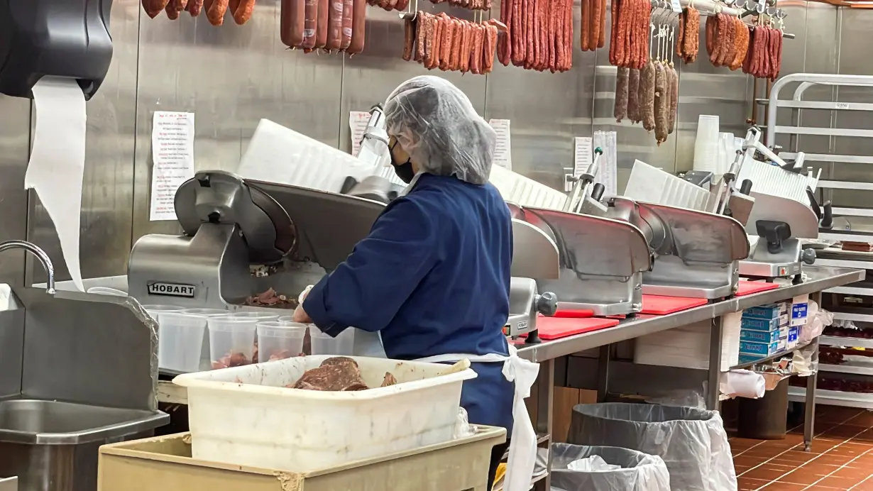 An employee uses a deli meat slicer at Paulina Meat Market in Chicago