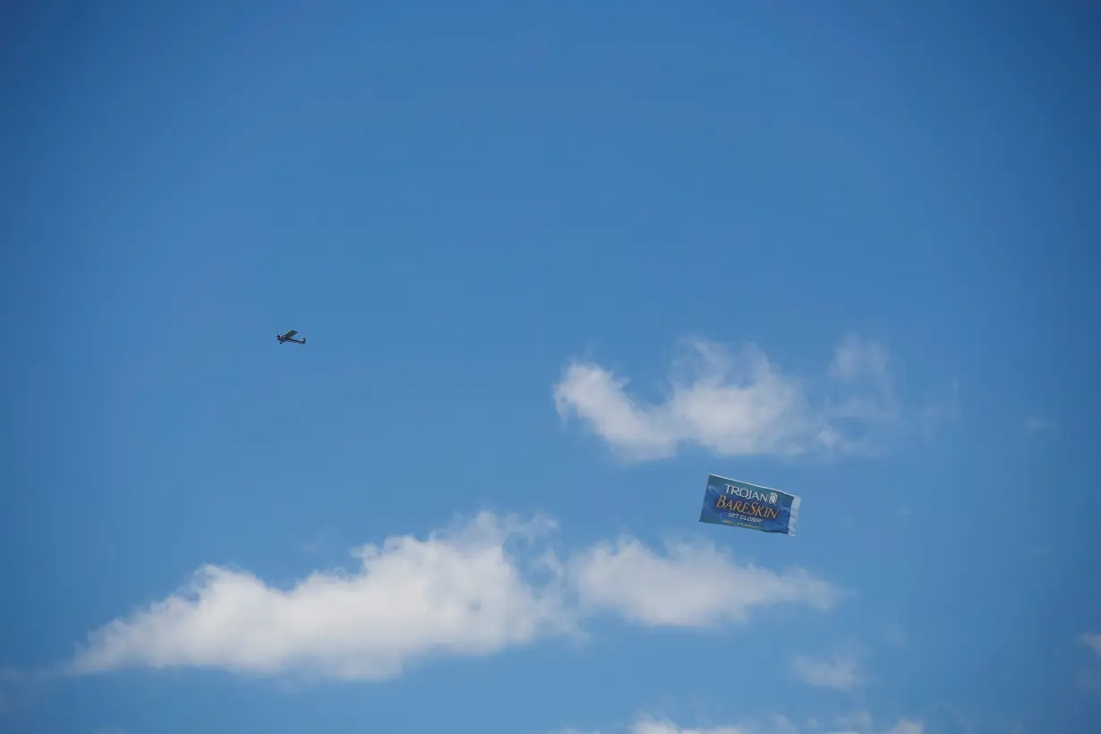 FILE PHOTO: A plane flies an advertisement for Trojan Bareskin condoms over the concert grounds on the second day of the Firefly Music Festival in Dover, Delaware U.S.