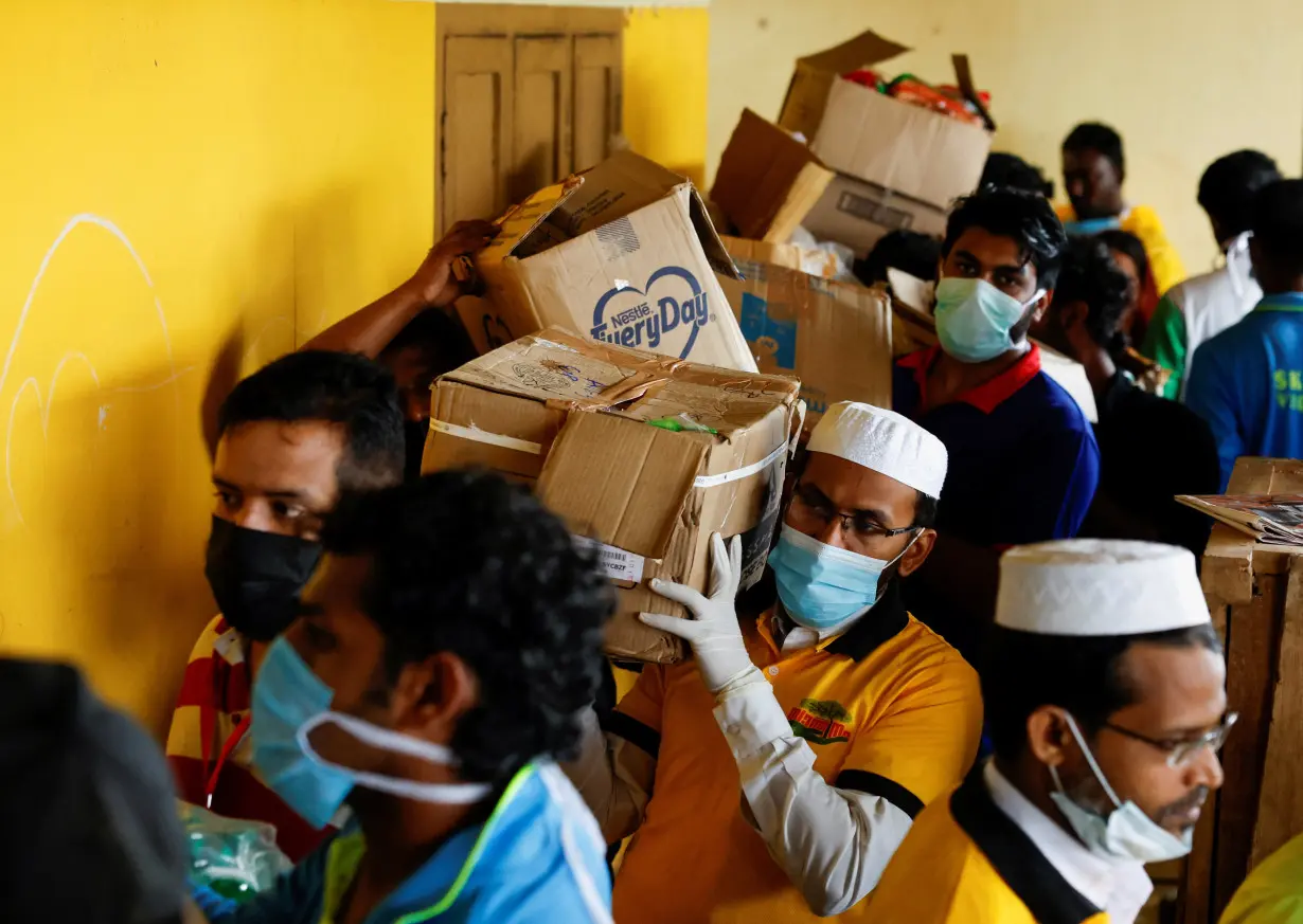 Volunteers carry boxes of rations to a relief camp after landslides hit several villages in Wayanad district, in Meppadi, in the southern state of Kerala