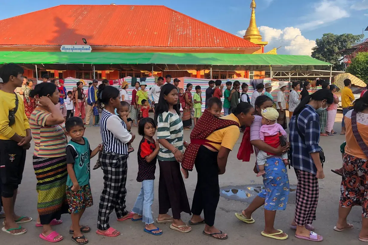 People queue for food at a monastery turned temporary shelter for internally displaced people in Lashio, Shan state in November 2023.