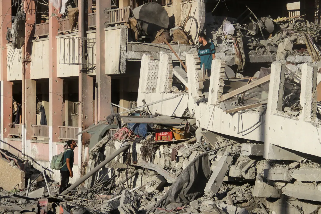 Palestinians inspect the site of Israeli strikes on a school sheltering displaced people, amid Israel-Hamas conflict, in Gaza City