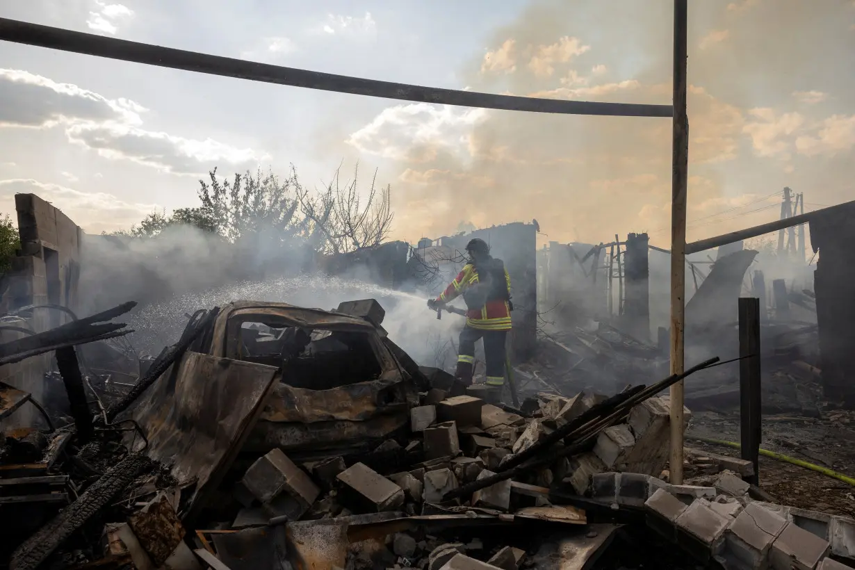 An emergency worker extinguishes a fire that destroyed a private house after a Russian strike on a residential area in Pokrovsk