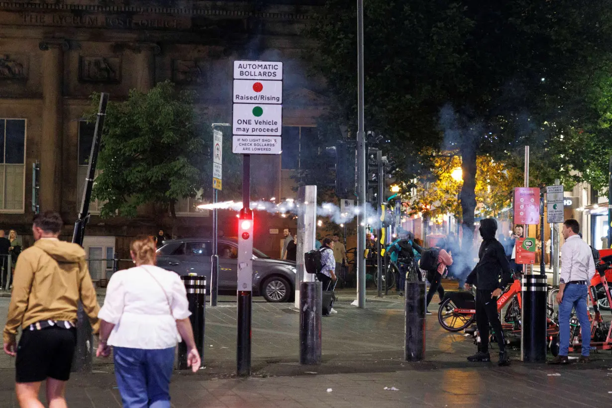 Protestors throw fireworks as the riots continue into the night in Liverpool