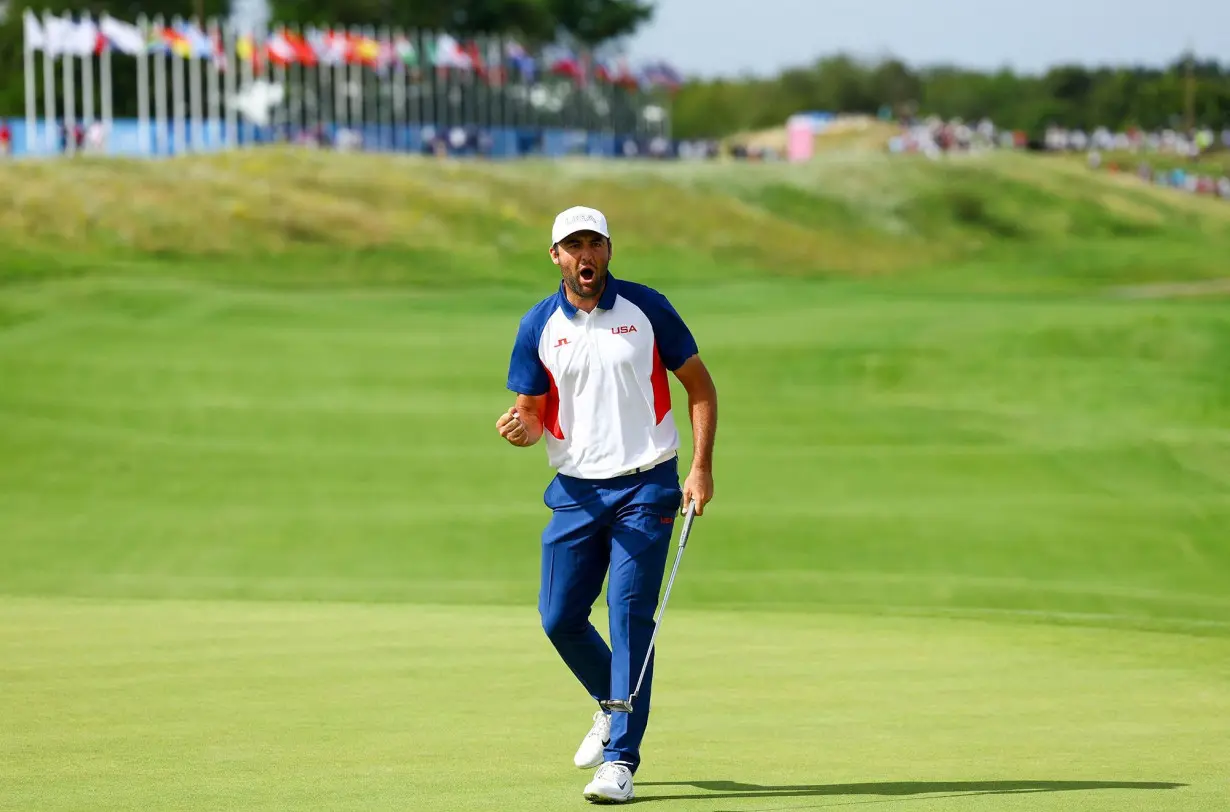 Scottie Scheffler celebrates during the men's golf competition on Sunday.