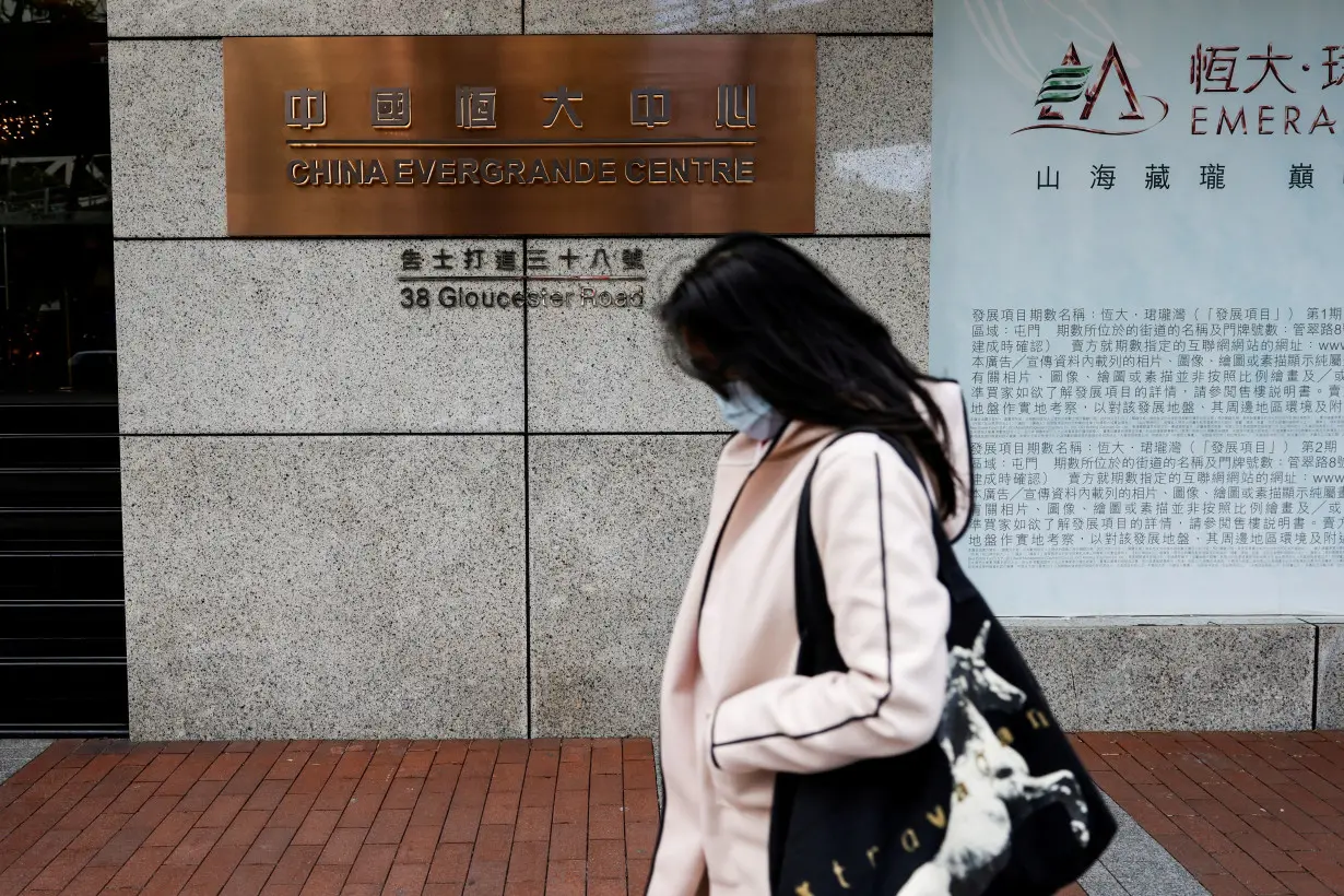 FILE PHOTO: A woman walks in front of the China Evergrande Centre building sign in Hong Kong