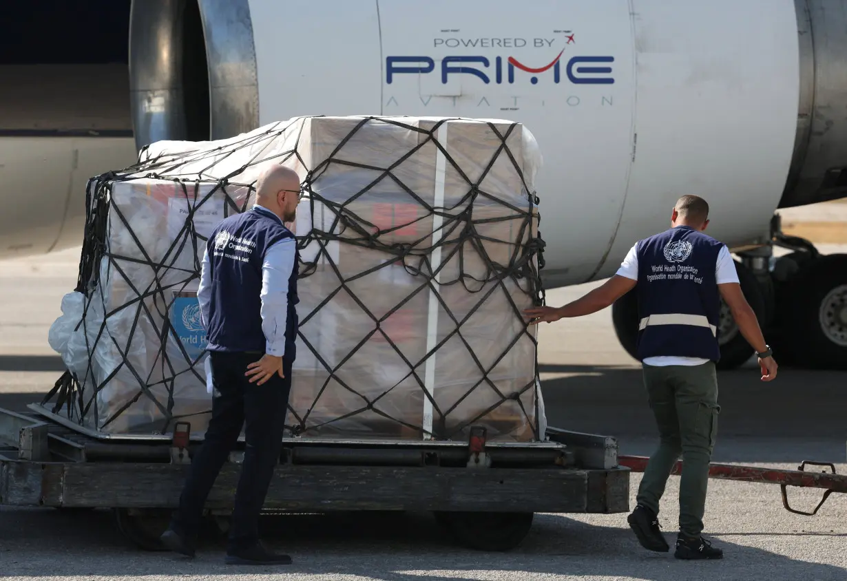 World Health Organization staff walk near medical supplies delivered by them for any potential health crisis resulting from hostilities, in Beirut