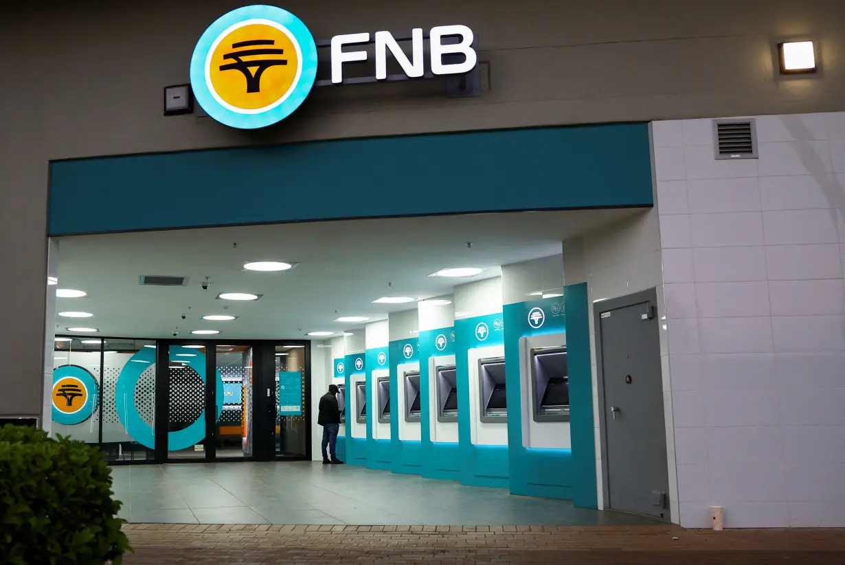 A customer uses an ATM, in Soweto