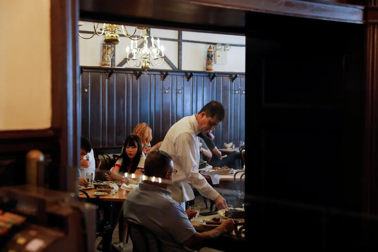 A waiter serves steak at Peter Luger Steak House in Brooklyn, New York City