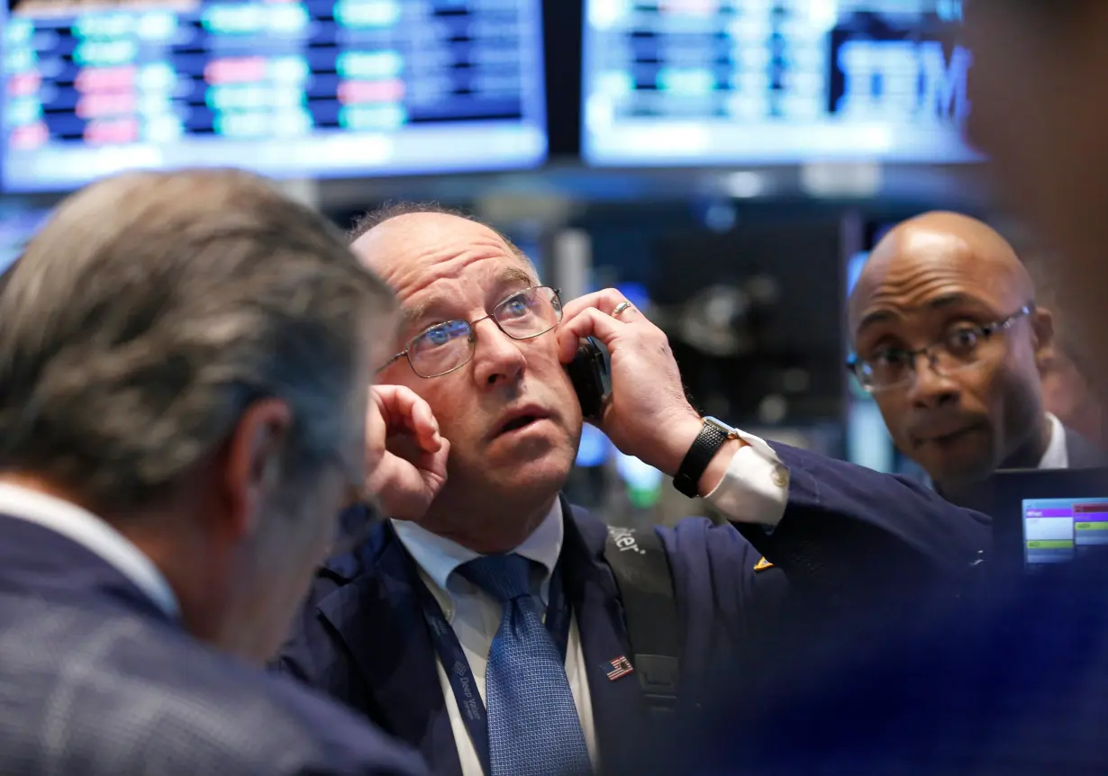 Traders work on the floor at the New York Stock Exchange