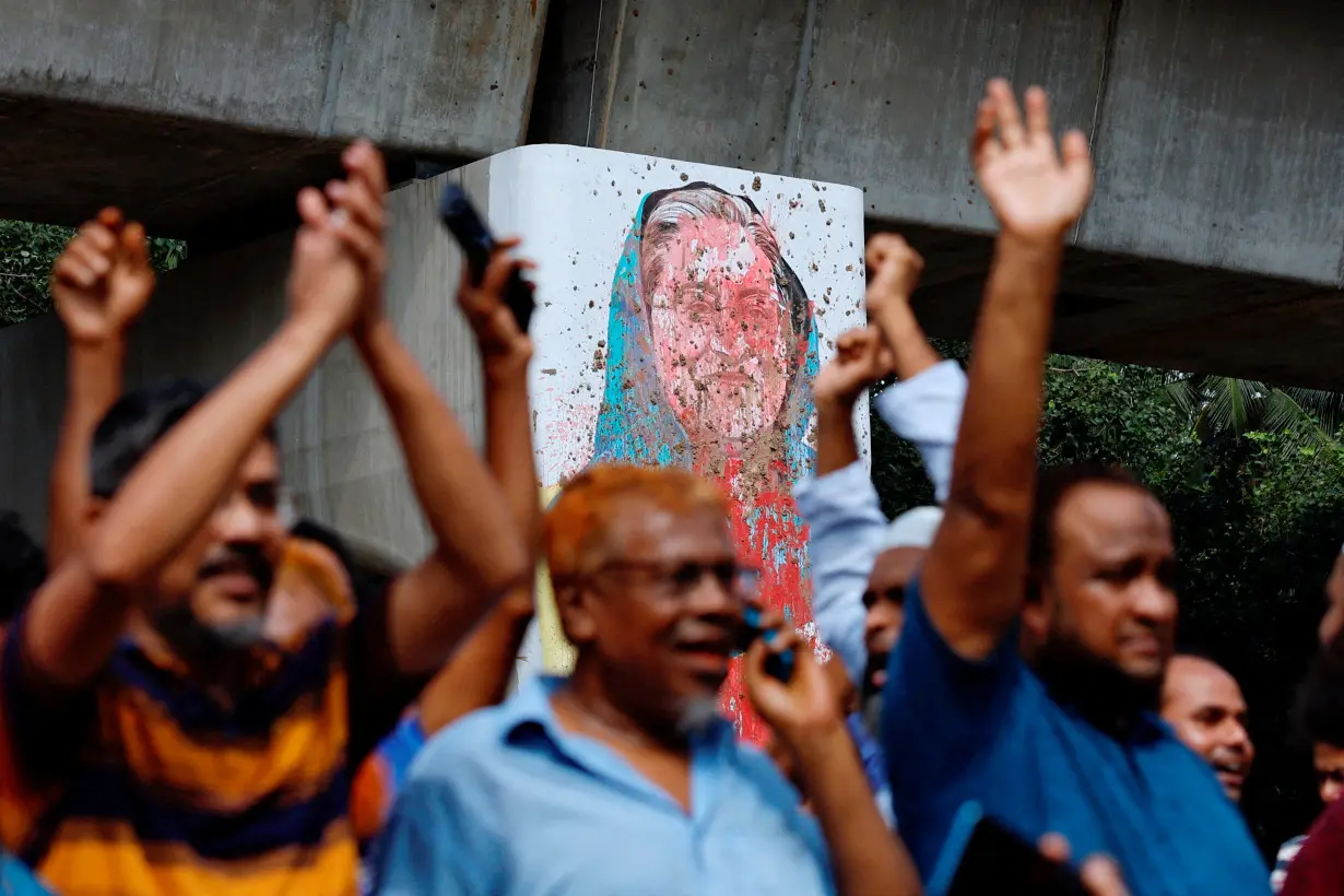 A mural of Prime Minister Sheikh Hasina is seen vandalised by protesters as people celebrate her resignation in Dhaka