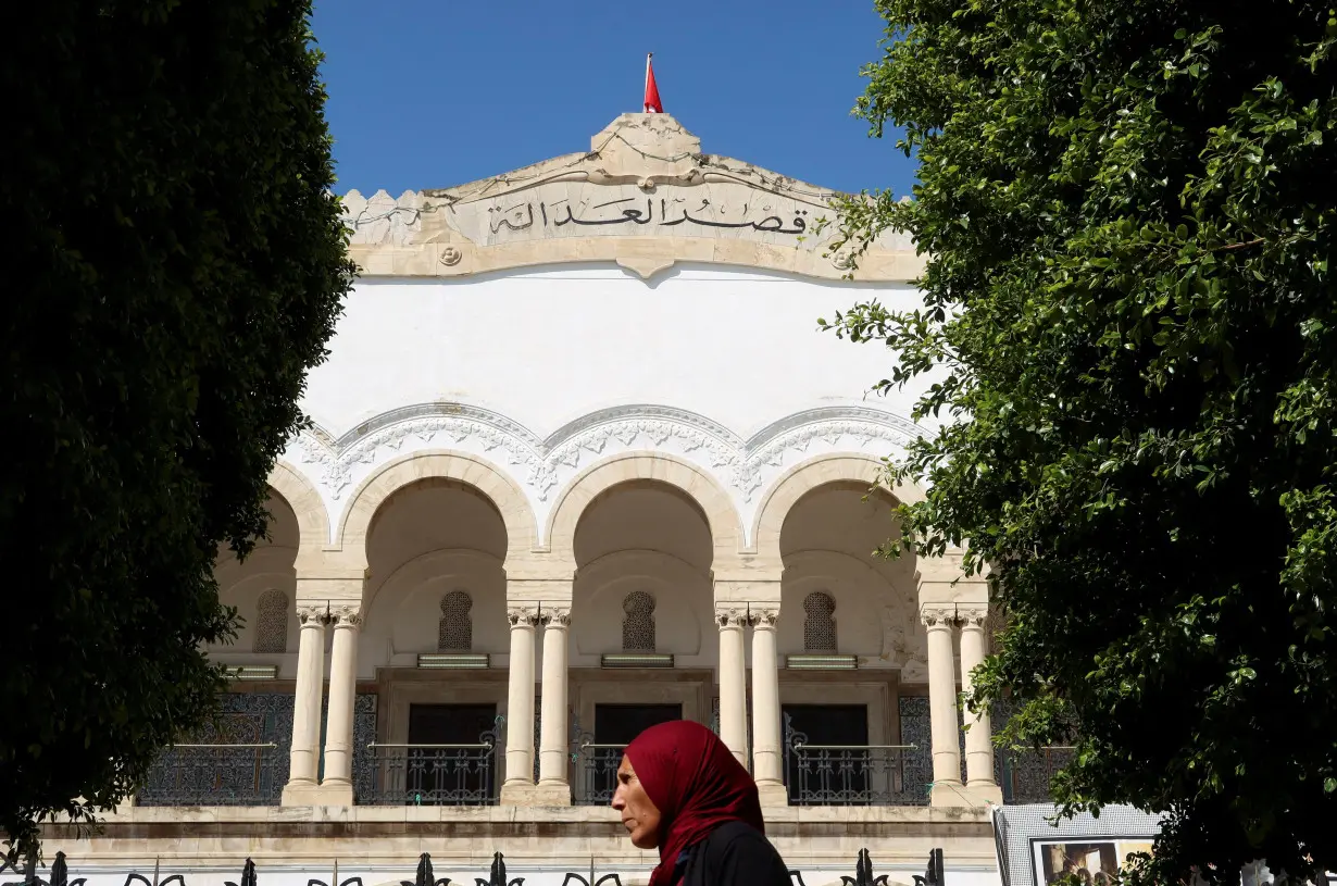 FILE PHOTO: A woman walks near the Palace of Justice in Tunis