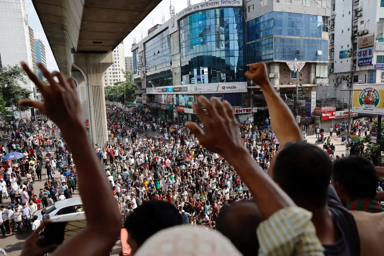 People wave hands as they celebrate the resignation of PM Sheikh Hasina in Dhaka