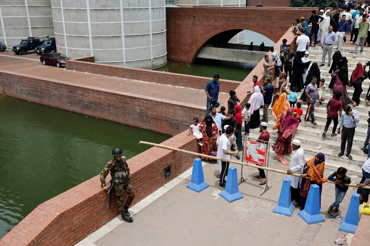 People gather at the entrance of the Parliament Building after Bangladeshi PM Hasina's resignation, in Dhaka