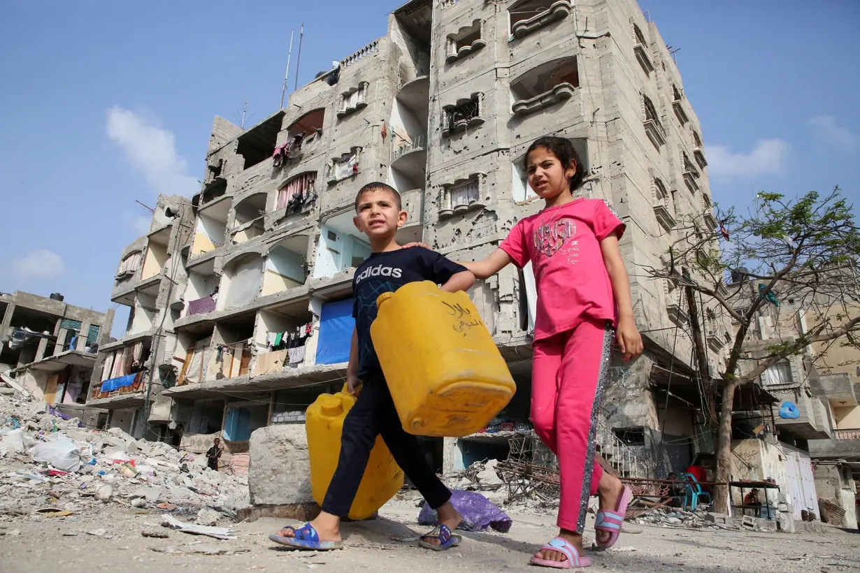 Palestinian children walk past a house damaged in an Israeli strike in Rafah, in the southern Gaza Strip, on May 1.