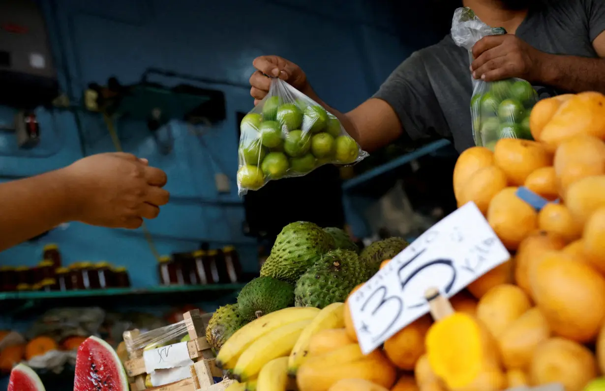 FILE PHOTO: A person buys lemons at a stall in a market in Monterrey