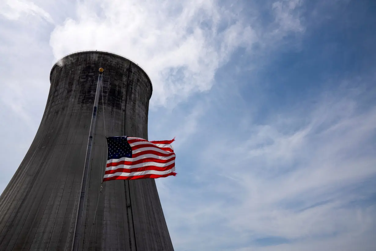 FILE PHOTO: The US flag flies in front of a coal-fired power plant's cooling tower at Duke Energy's Crystal River Energy Complex in Crystal River, Florida