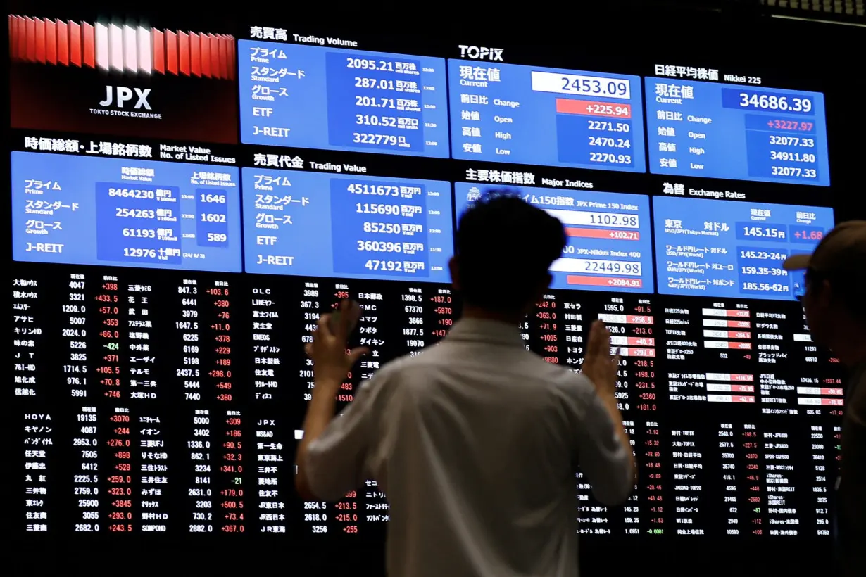 Media members observe the stock quotation board at Tokyo Stock Exchange in Tokyo