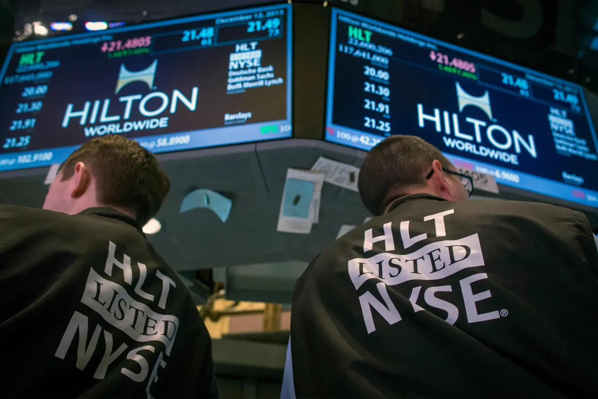 Traders wear special vests for the Hilton IPO on the floor of the New York Stock Exchange