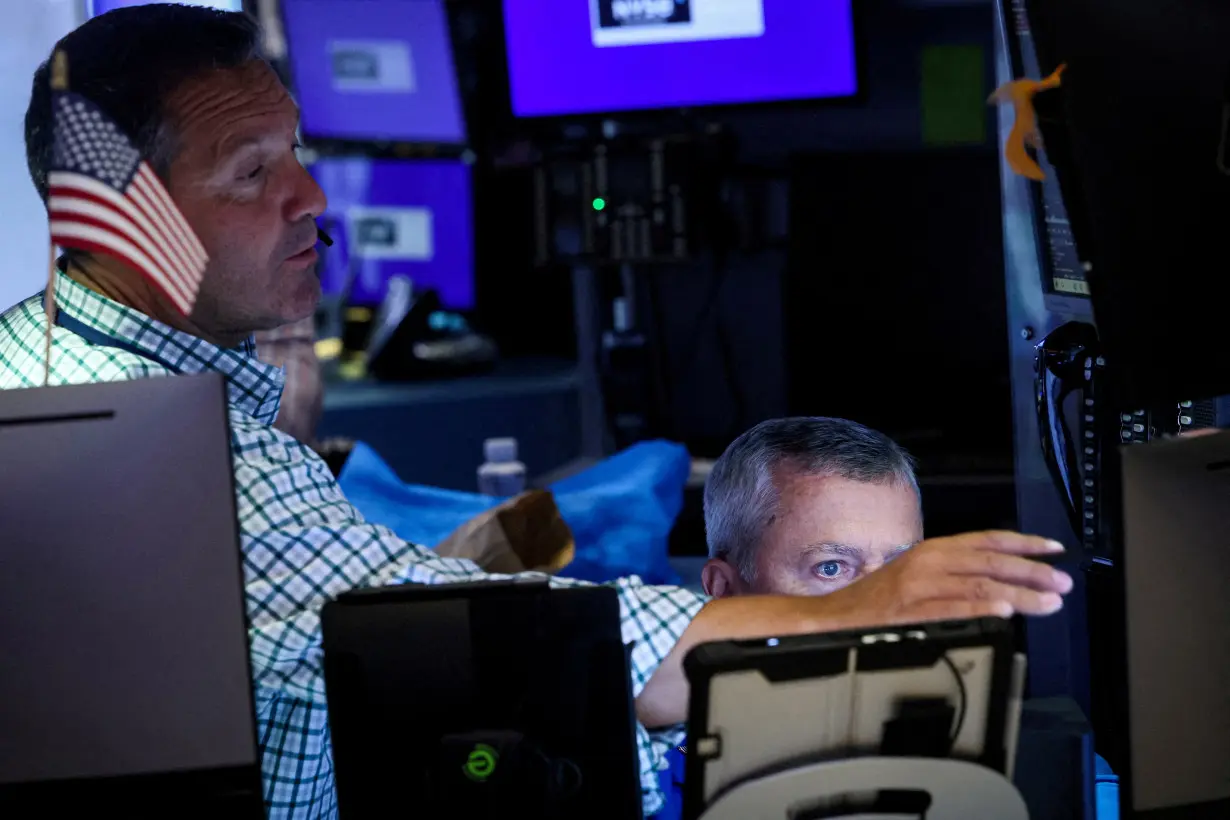 FILE PHOTO: Traders work on the floor of the NYSE in New York