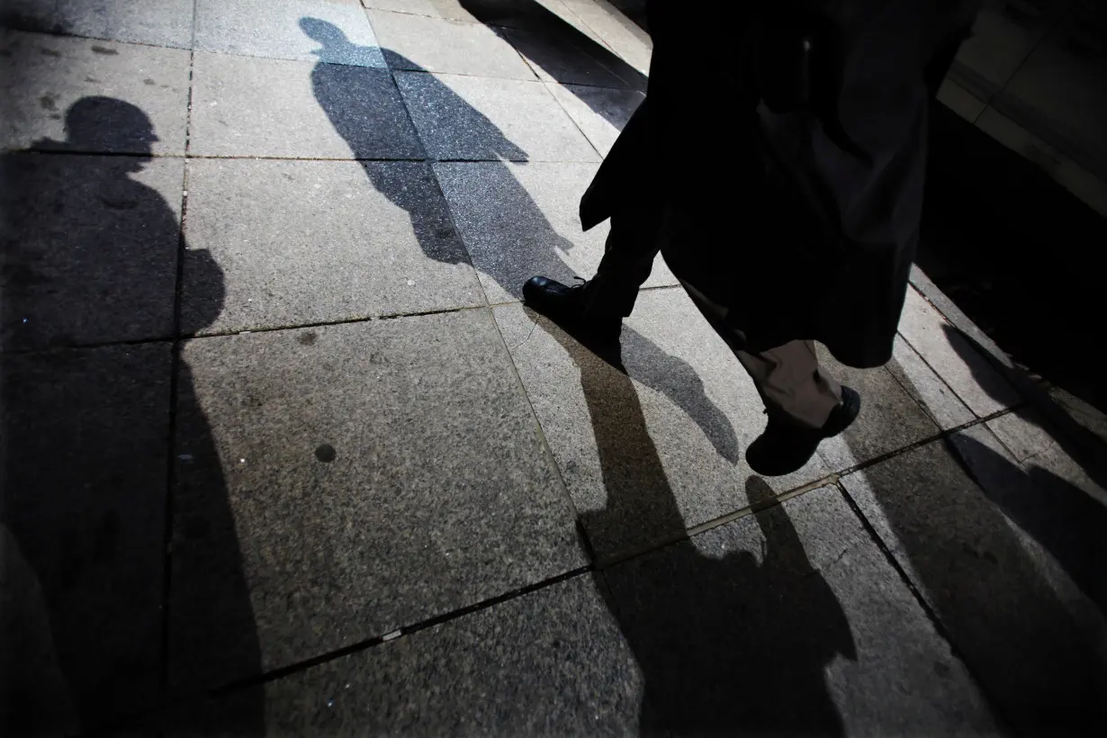 Shadows are seen as a man walks down Bay Street in the financial district in Toronto