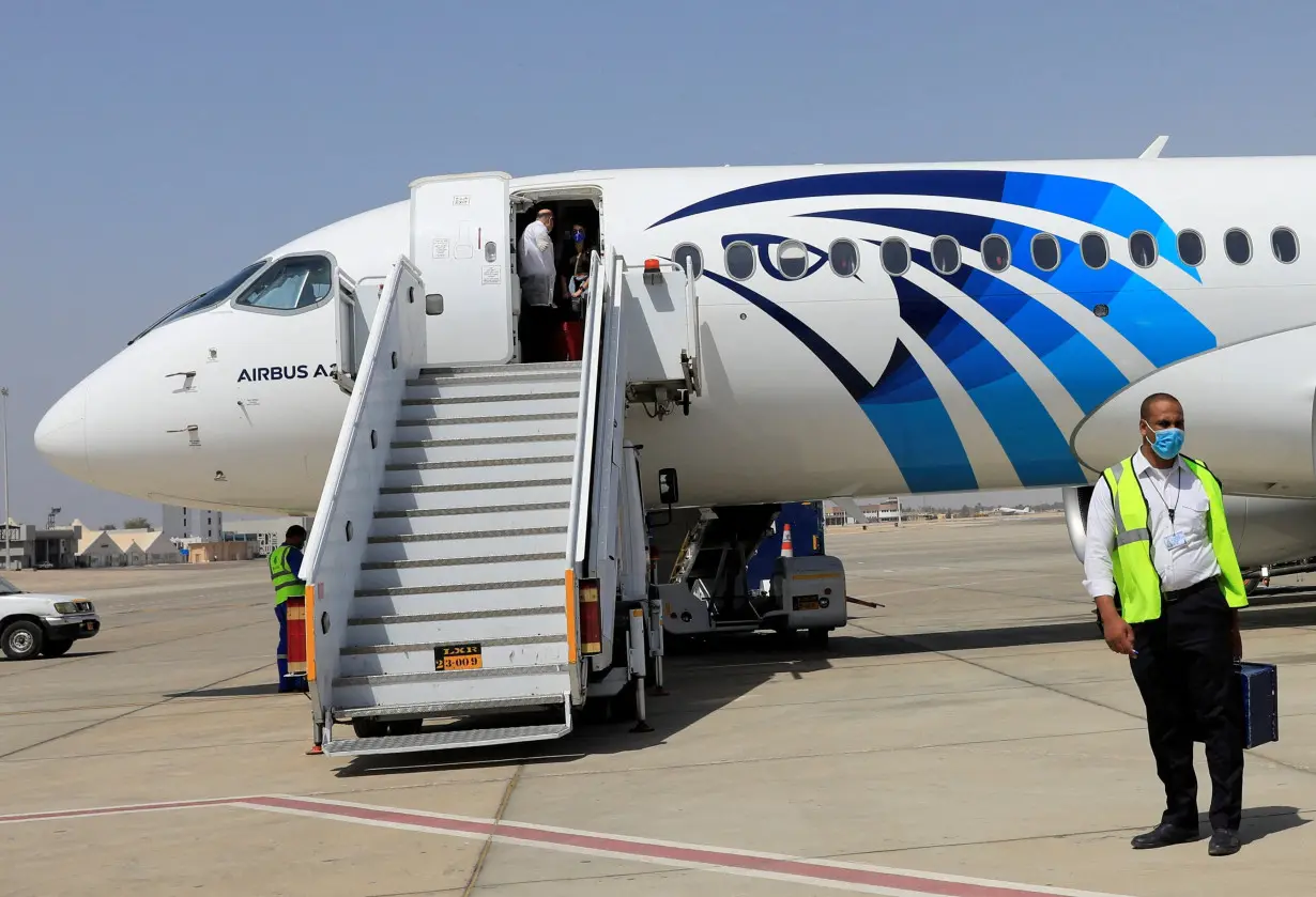 FILE PHOTO: Employee of Luxor's International Airport walks next to an EgyptAir plane, in Luxor