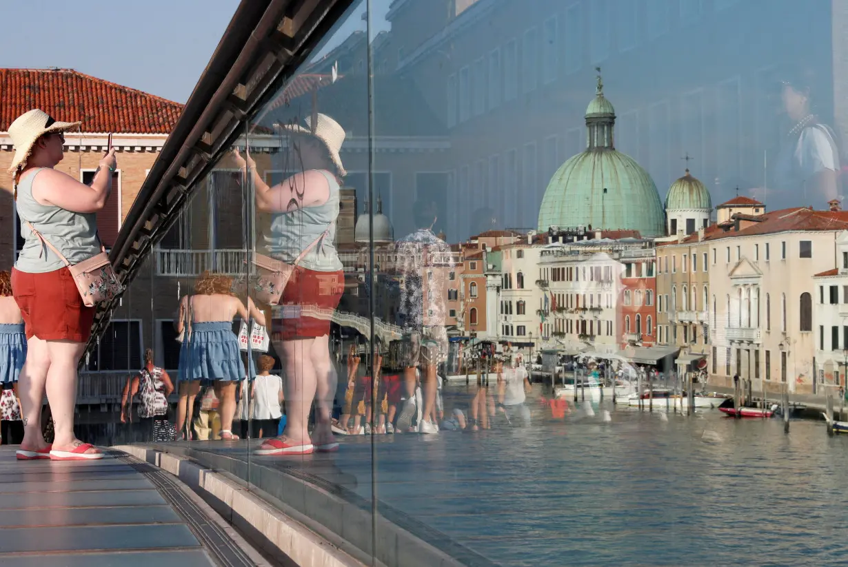 FILE PHOTO: Woman takes a picture from Ponte della Costituzione (Constitution Bridge) in Venice