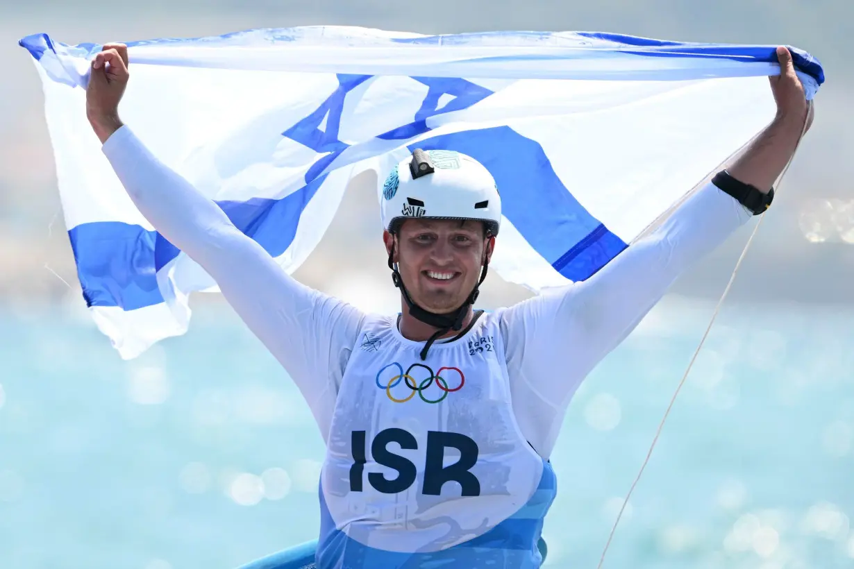 Israel's Tom Reuveny celebrates winning the gold in men's windsurf iQFoil class final at Marseille Marina on August 3.