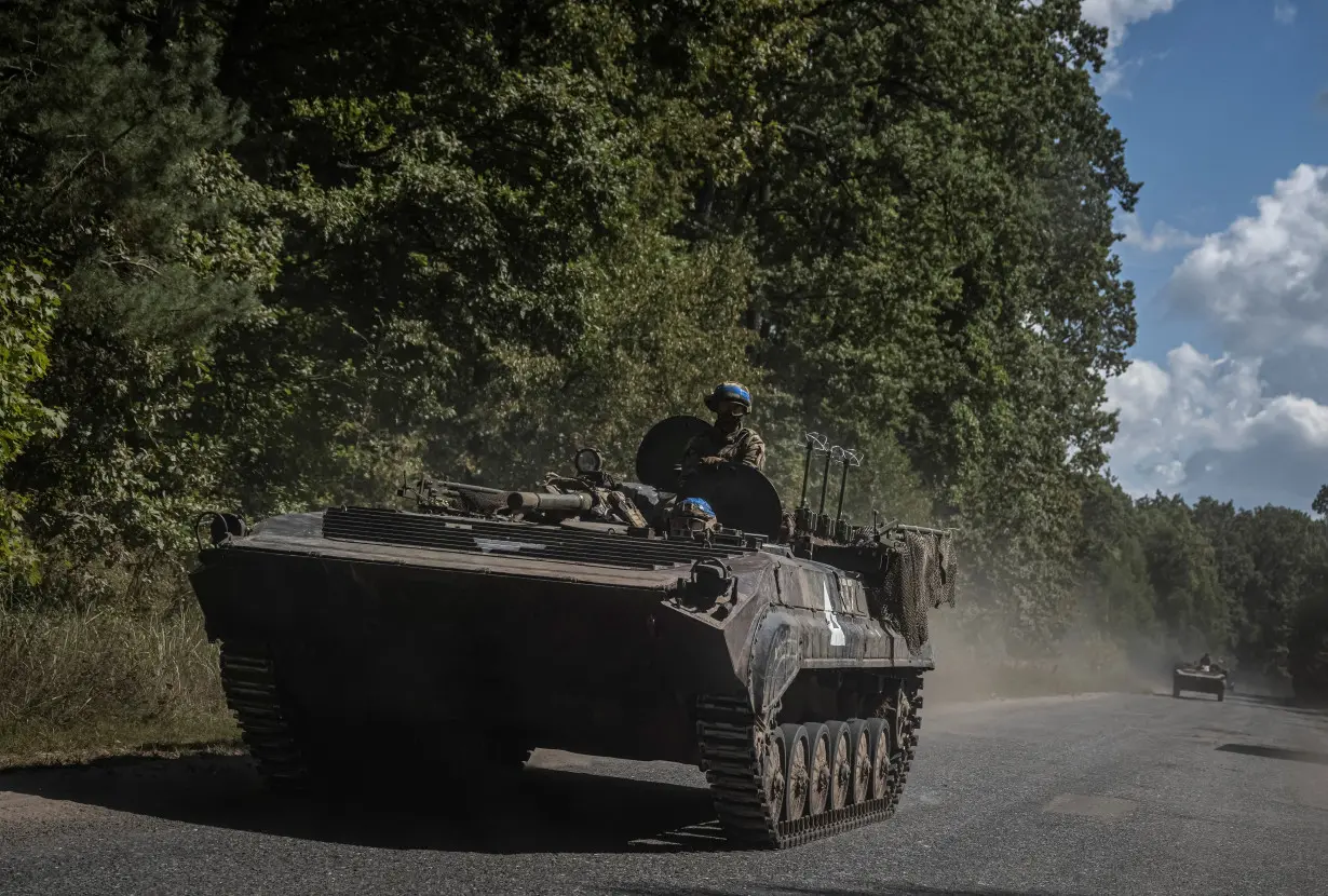 Ukrainian service members ride a BMP-1 infantry fighting vehicle near the Russian border in Sumy region