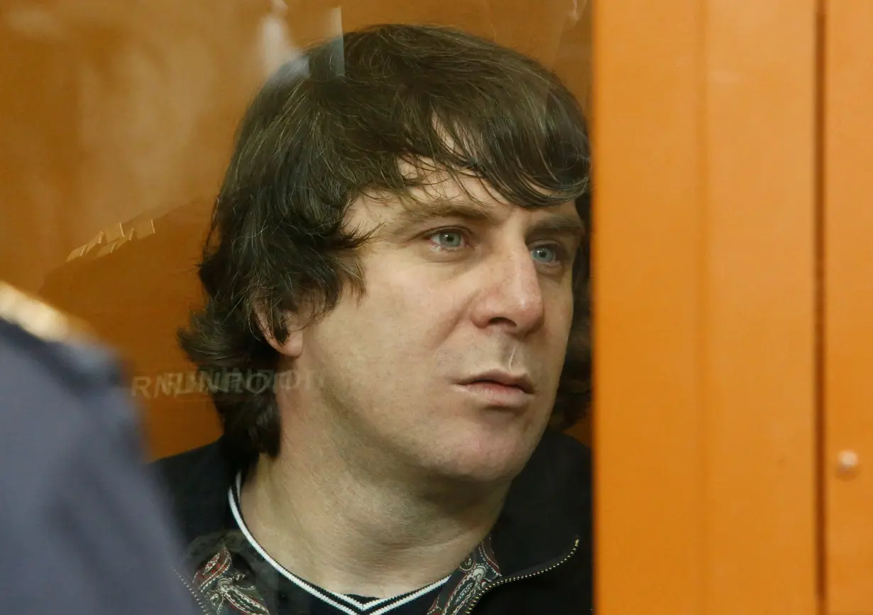 FILE PHOTO: Eskerkhanov, who is suspected of involvement in the killing of opposition figure Nemtsov, sits inside a glass-walled cage during their trial at the Moscow military district court