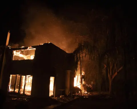 A wildfire near Greece's capital darkens the skies over Athens and advances fast
