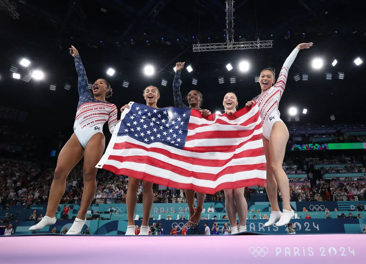 (Left to right) Team USA's Jordan Chiles, Hezly Rivera, Simone Biles, Jade Carey, and Sunisa Lee celebrate winning the Paris Olympics' artistic gymnastics women's team final.