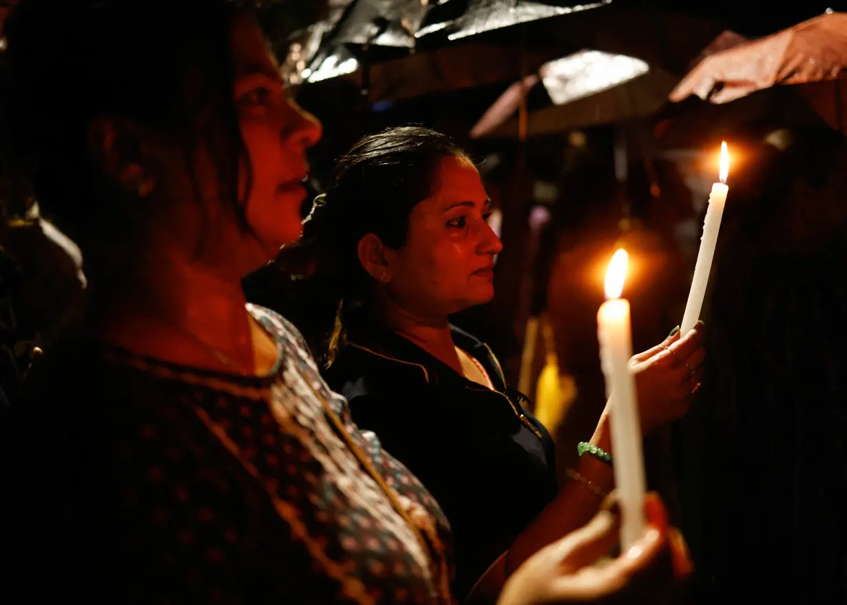 Women hold candles as they attend a candlelight vigil condemning the rape and murder of a trainee medic at a government-run hospital in Kolkata