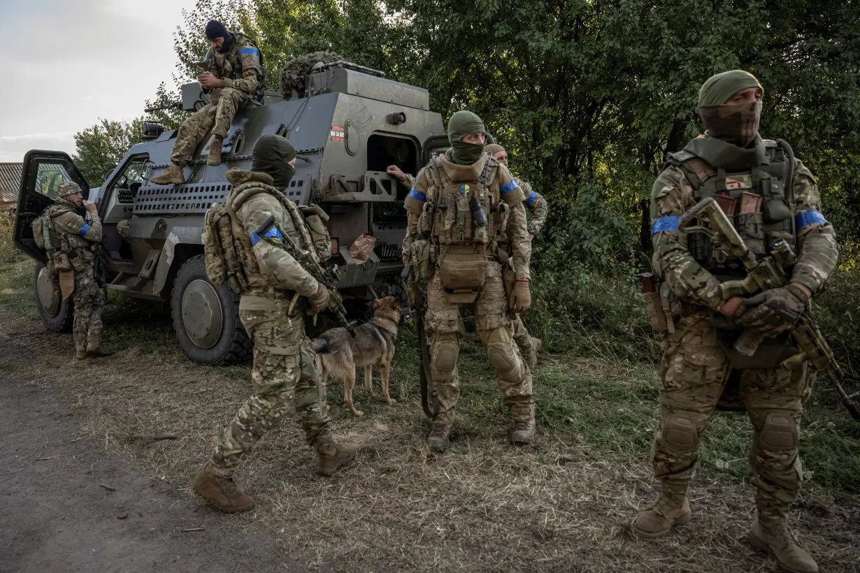 Ukrainian servicemen stand near a military vehicle, near the Russian border in Sumy region