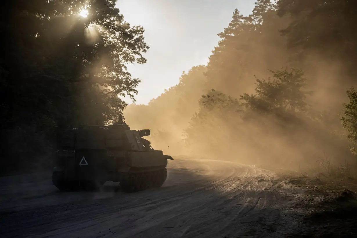 Ukrainian servicemen ride a M109 Paladin self-propelled howitzer near the Russian border in Sumy region