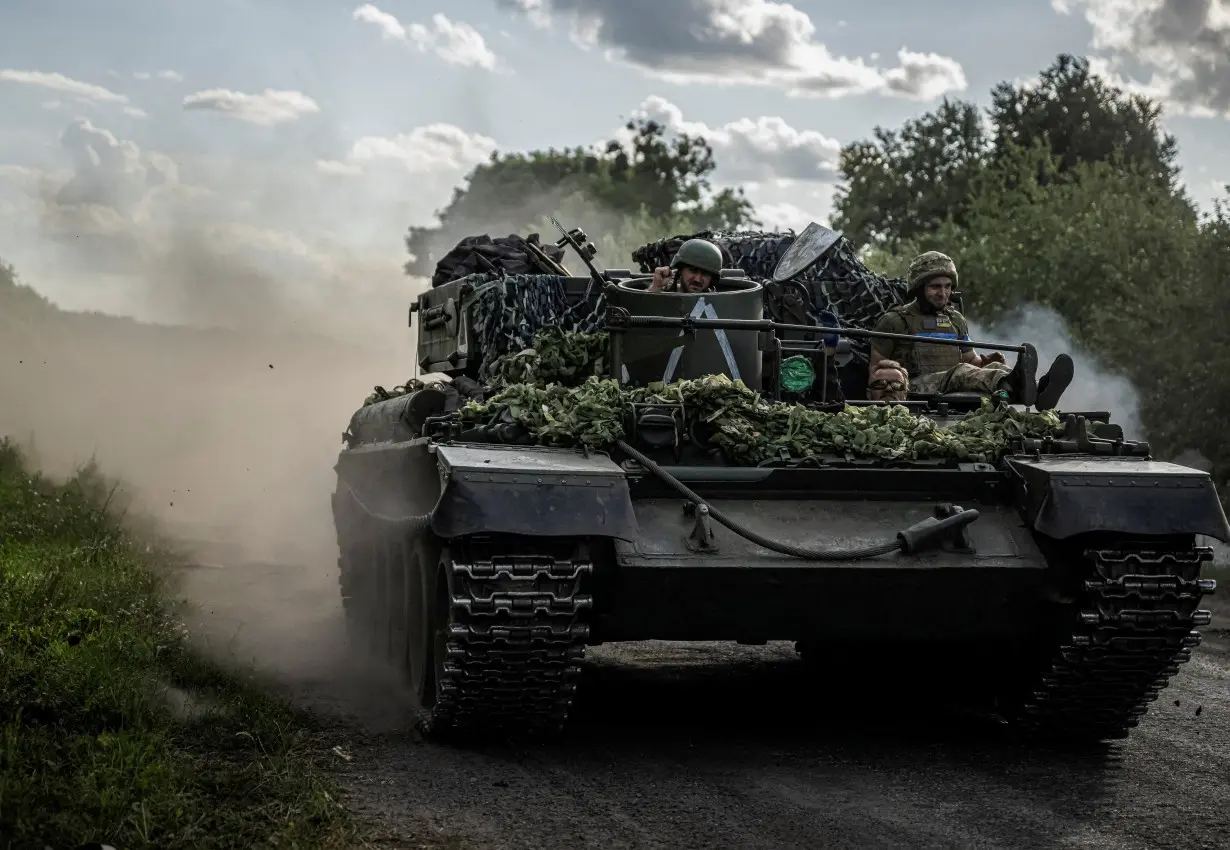 FILE PHOTO: Ukrainian servicemen ride a military vehicle near the Russian border in Sumy region