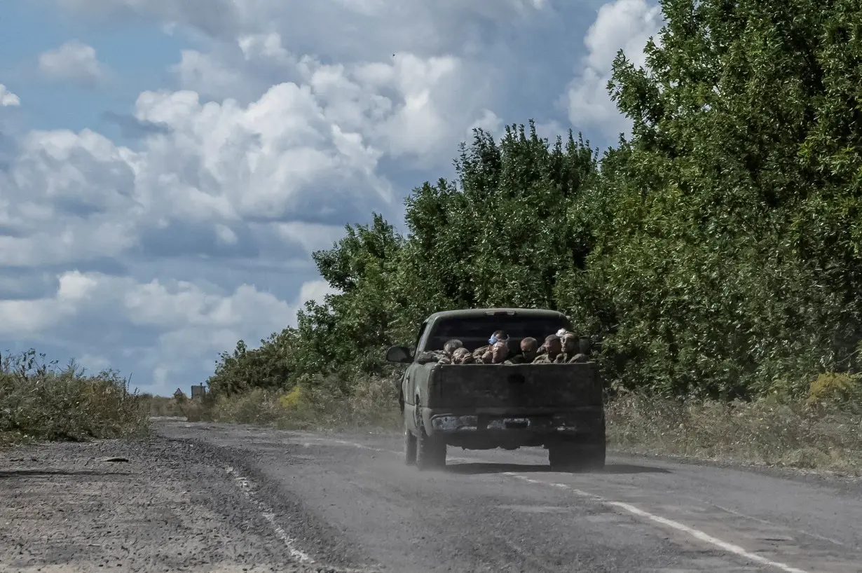 FILE PHOTO: Ukrainian soldiers ride a military vehicle with Russian POWs in the truck bed near the Russian border in Sumy region