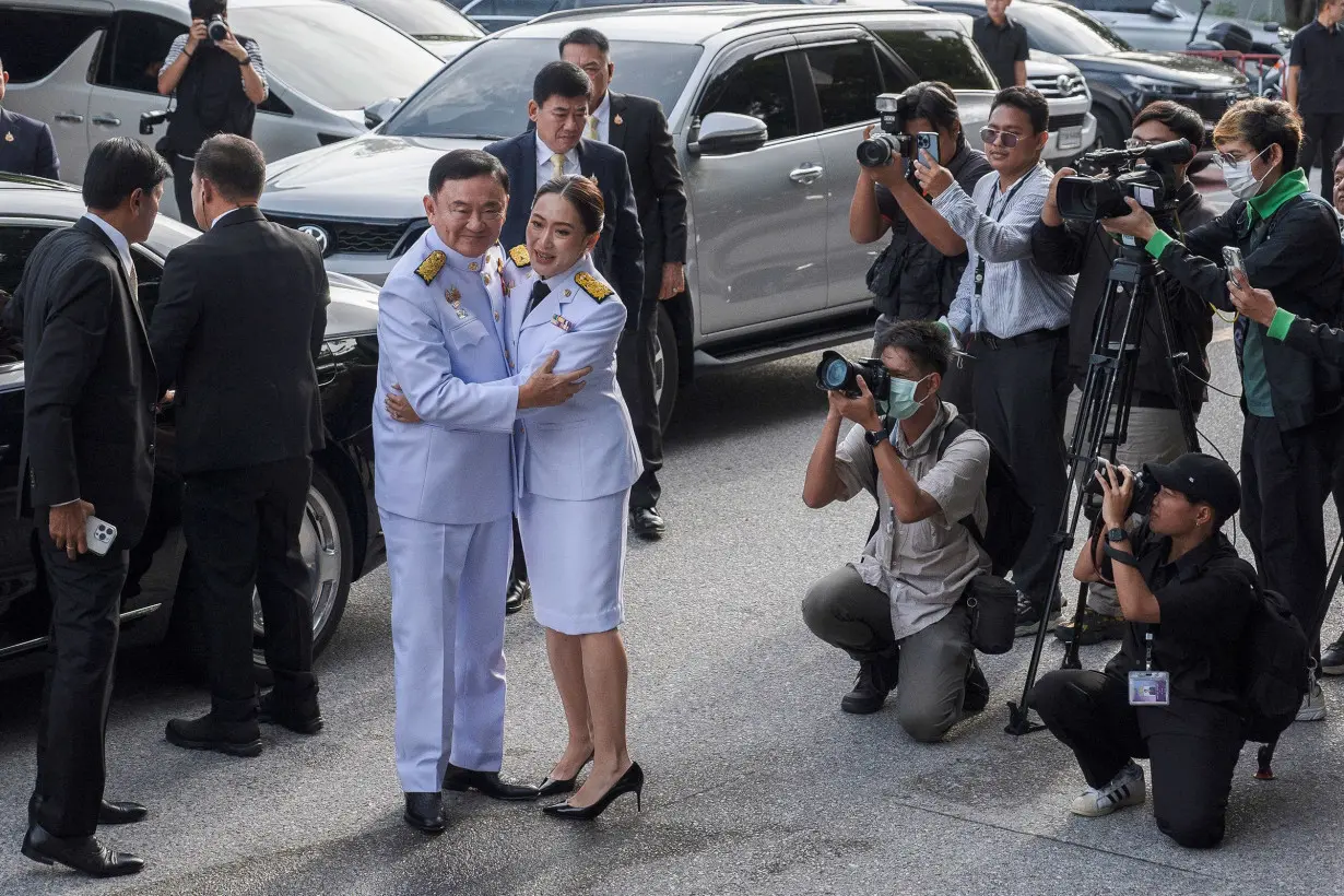 Paetongtarn Shinawatra embraces her father Thaksin Shinawatra as they arrive for the royal endorsement ceremony in Bangkok, Thailand, on August 18, 2024.