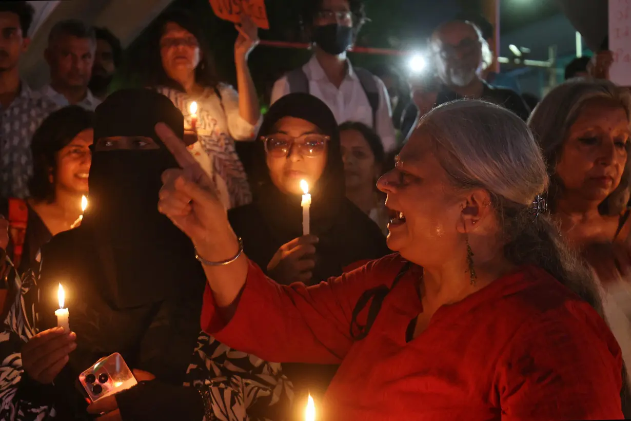 Social activists hold candles and shout slogans during a protest demanding justice following the rape and murder of a trainee medic at a hospital in Kolkata, in Ahmedabad,