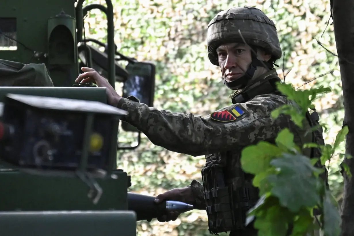 Ukraine serviceman holds a shell for a Caesar self-propelled howitzer before firing towards Russian troops outside the town of Pokrovsk