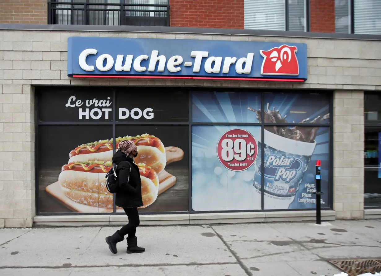 A pedestrian walks past a Couche-Tard convenience store in Montreal