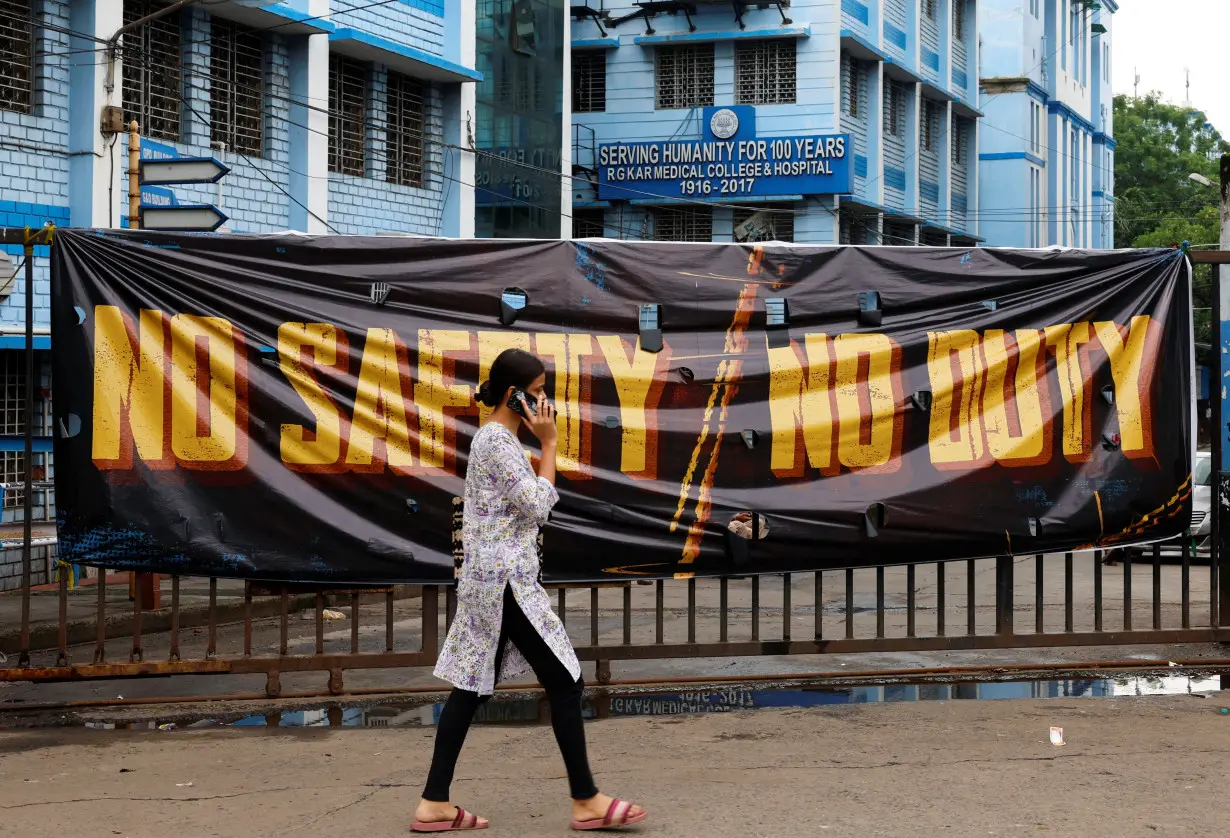 A woman walks past a closed gate of R G Kar Medical College and Hospital in Kolkata