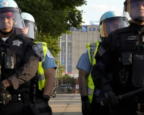 Some protesters tear down security fence as thousands march outside Democratic National Convention