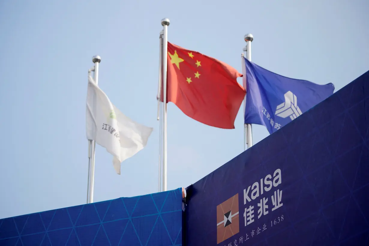 FILE PHOTO: A sign of Kaisa is seen in front a Chinese flag at a construction site that is being developed by Kaisa Group Holdings