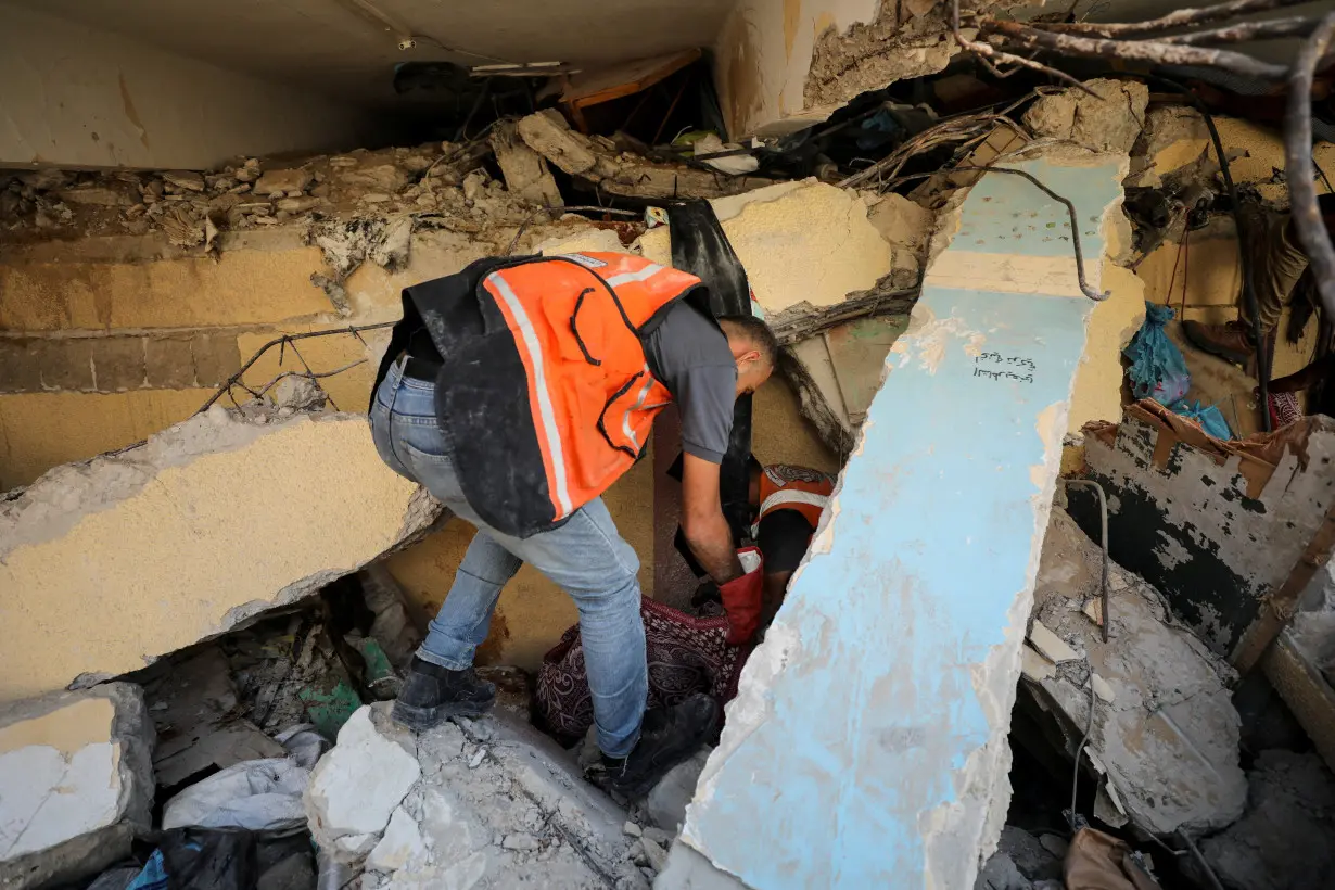 Palestinians inspect a school sheltering displaced people after it was hit by an Israeli strike, in Gaza City