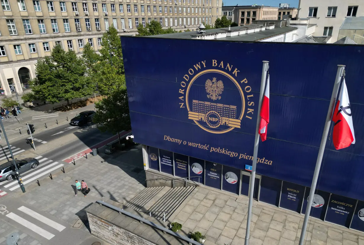 People walk in front of the Polish Central Bank (NBP) in Warsaw